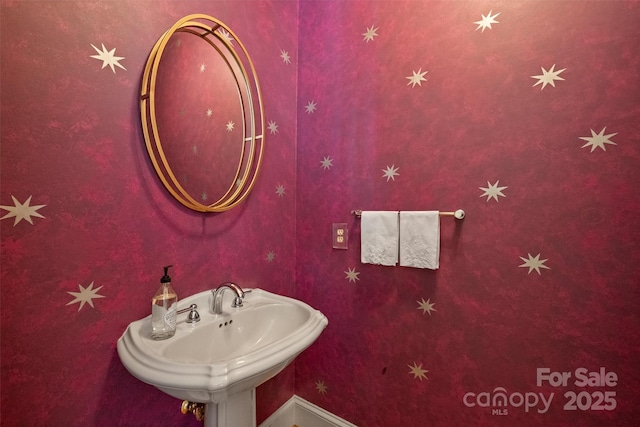 bathroom featuring baseboards and a sink