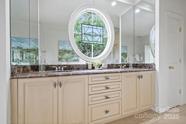 full bathroom with double vanity, tile patterned flooring, ornamental molding, and a sink