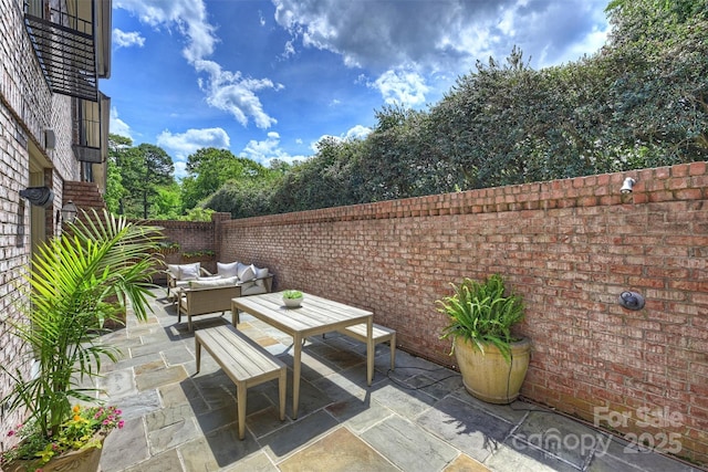 view of patio featuring outdoor lounge area and fence