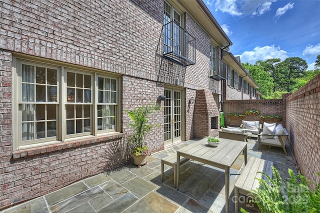 wooden terrace featuring a patio area, a fenced backyard, outdoor lounge area, and french doors