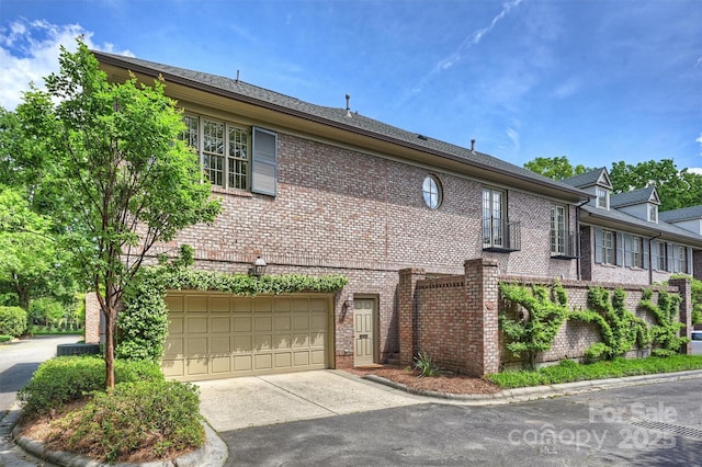view of front facade with an attached garage, brick siding, and driveway