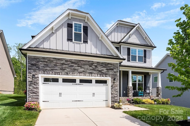 craftsman-style home featuring stone siding, covered porch, board and batten siding, concrete driveway, and a front lawn