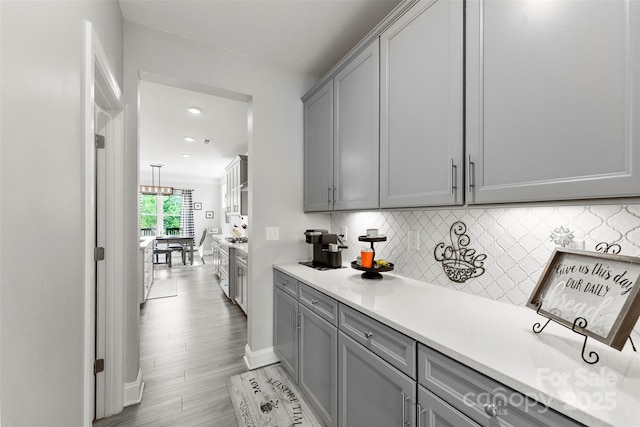 bar area with tasteful backsplash, light wood-type flooring, stainless steel range oven, baseboards, and recessed lighting