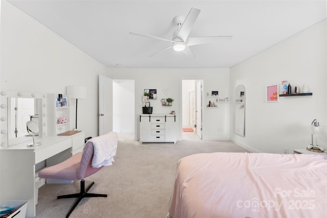 bedroom featuring light carpet, a desk, baseboards, and a ceiling fan