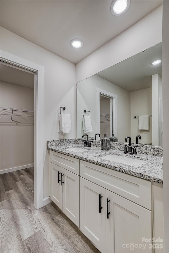 721 32nd St NE, Conover, NC 28613 - full bath featuring double vanity, wood finished floors, a walk in closet, and a sink