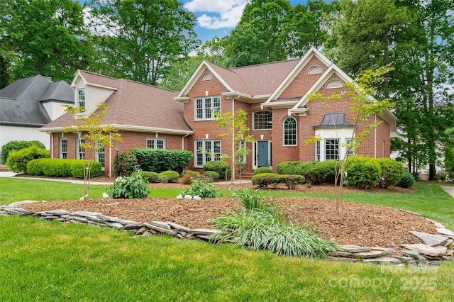 view of front of house featuring a front lawn and brick siding