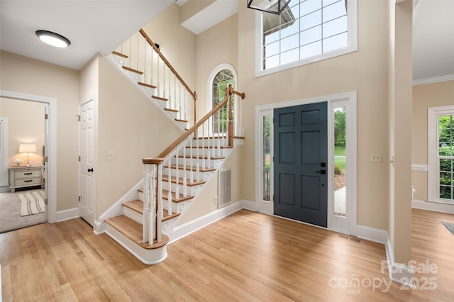 entryway with wood finished floors, visible vents, and baseboards