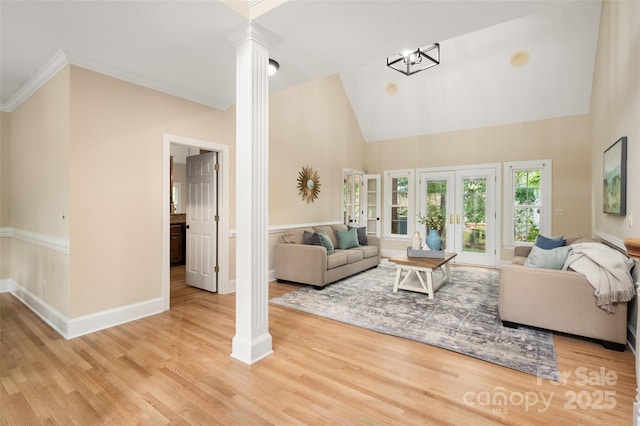 living room featuring high vaulted ceiling, decorative columns, wood finished floors, and baseboards