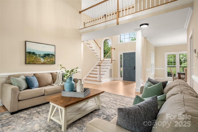 living room with stairway, wood finished floors, and plenty of natural light
