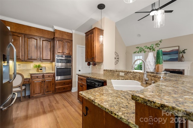 kitchen with light stone countertops, a sink, light wood-style floors, a ceiling fan, and appliances with stainless steel finishes