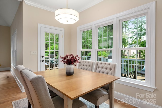 dining space with crown molding, light wood-style floors, and baseboards