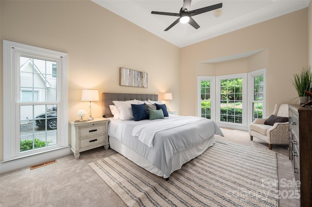bedroom with vaulted ceiling, light carpet, visible vents, a ceiling fan, and crown molding
