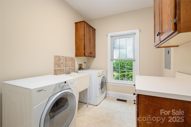 laundry area with washing machine and dryer, visible vents, electric panel, baseboards, and cabinet space