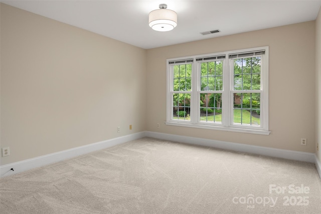 spare room with visible vents, carpet, and baseboards