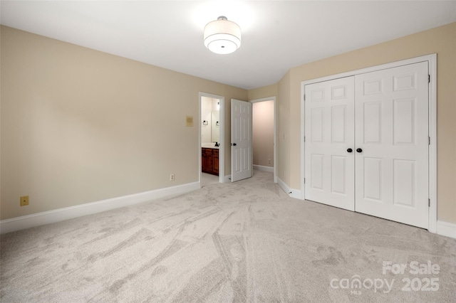 unfurnished bedroom featuring light colored carpet, connected bathroom, a closet, and baseboards