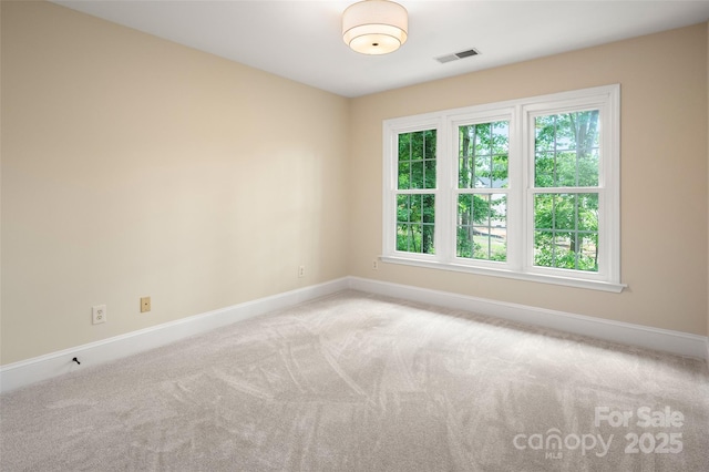 spare room with baseboards, visible vents, and carpet floors