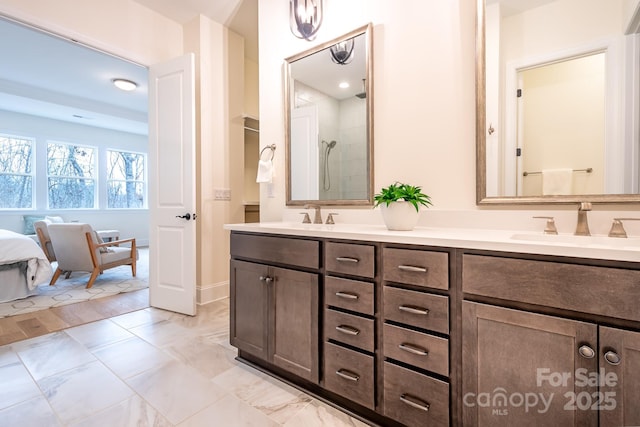 bathroom featuring a sink, double vanity, and a shower with door