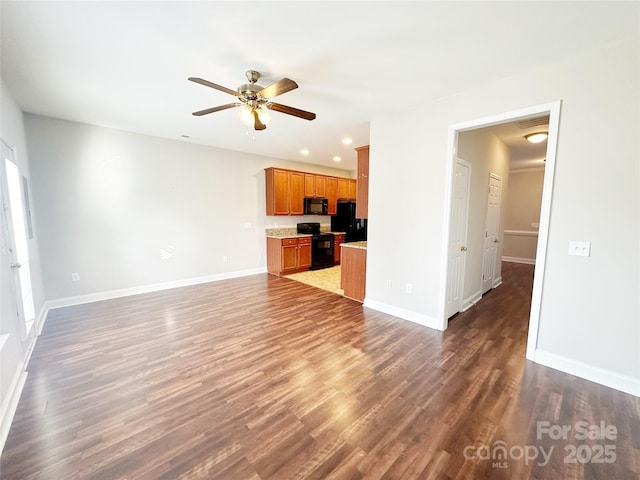 unfurnished living room featuring wood finished floors, baseboards, and ceiling fan