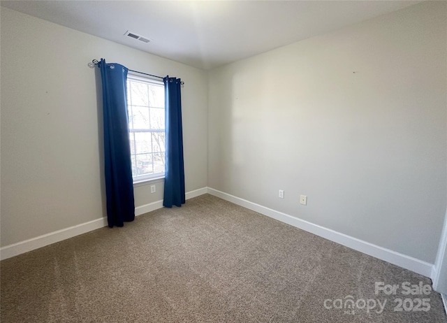empty room featuring baseboards, visible vents, and carpet flooring