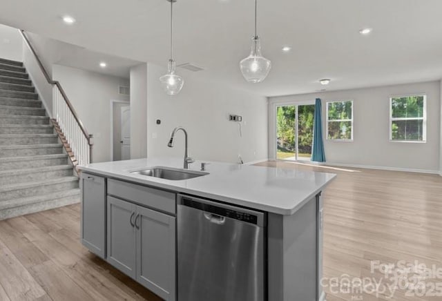 5024 Colline Ct, Charlotte, NC 28216 - kitchen featuring stainless steel dishwasher, a sink, open floor plan, gray cabinets, and light wood-type flooring