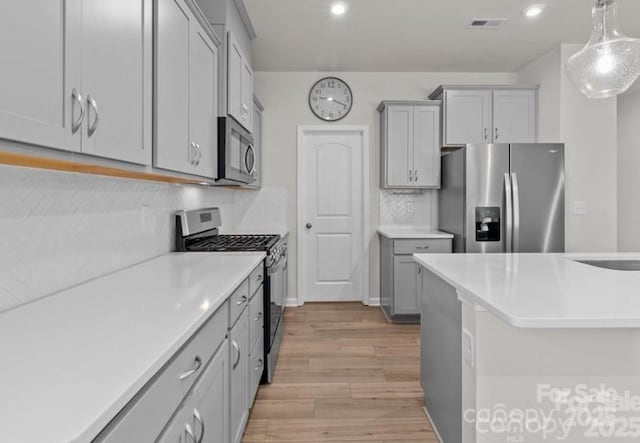5024 Colline Ct, Charlotte, NC 28216 - kitchen featuring stainless steel appliances, gray cabinetry, light wood-type flooring, light countertops, and recessed lighting