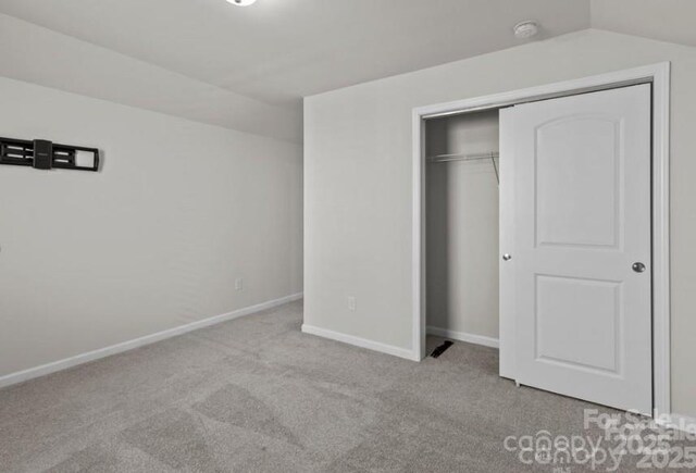 5024 Colline Ct, Charlotte, NC 28216 - unfurnished bedroom with carpet, baseboards, a closet, and vaulted ceiling
