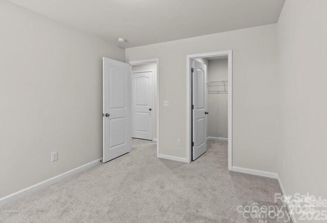 5024 Colline Ct, Charlotte, NC 28216 - unfurnished bedroom with carpet floors, baseboards, and a walk in closet