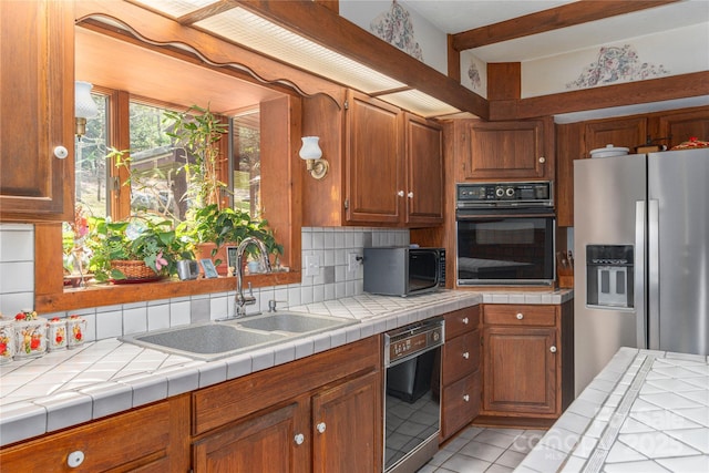 22 Waynewood Dr, Waynesville, NC 28786 - kitchen featuring a sink, light tile patterned floors, brown cabinetry, tasteful backsplash, and black appliances