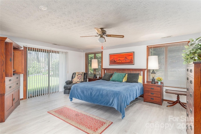 22 Waynewood Dr, Waynesville, NC 28786 - bedroom featuring light wood finished floors, ceiling fan, access to exterior, visible vents, and a textured ceiling