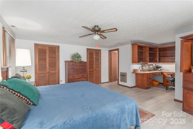 22 Waynewood Dr, Waynesville, NC 28786 - bedroom featuring ceiling fan, visible vents, heating unit, light wood finished floors, and multiple closets