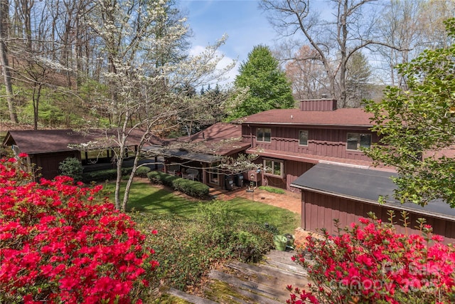 22 Waynewood Dr, Waynesville, NC 28786 - back of house with a lawn, roof with shingles, board and batten siding, and a chimney