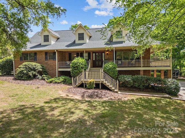 new england style home with brick siding, stairway, a front lawn, and covered porch