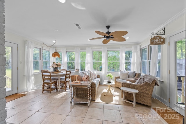sunroom with plenty of natural light, tile patterned flooring, and ornamental molding