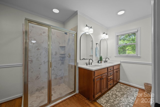 full bath with double vanity, a shower stall, ornamental molding, and a sink