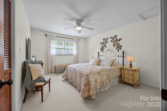 bedroom featuring attic access, a ceiling fan, baseboards, and light carpet