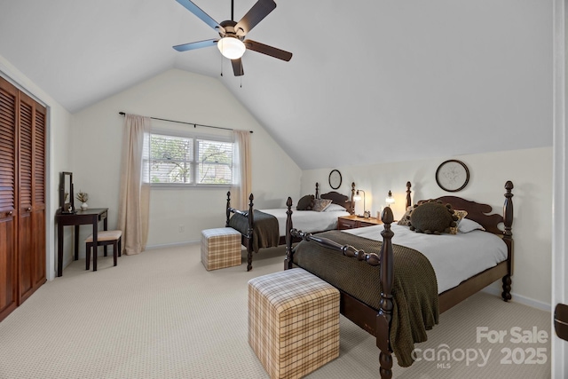 carpeted bedroom with vaulted ceiling, a closet, a ceiling fan, and baseboards