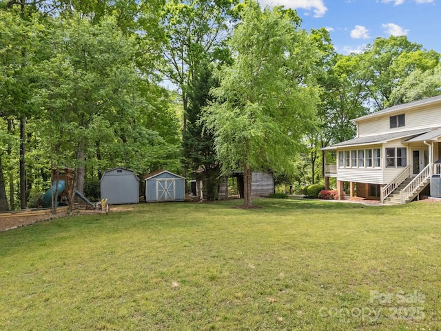 view of yard featuring stairs, central AC, an outbuilding, a storage unit, and a sunroom