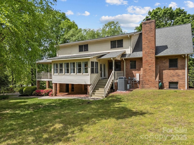 back of property featuring a lawn, a shingled roof, and a chimney