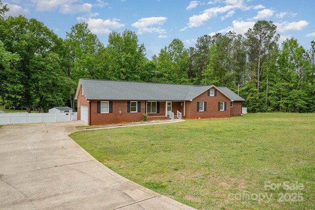 ranch-style home featuring a porch, fence, driveway, and brick siding