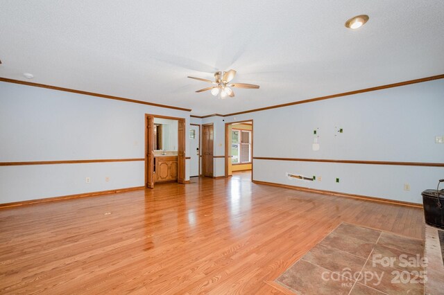 empty room with crown molding, ceiling fan, baseboards, and light wood finished floors