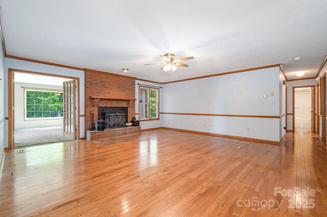 unfurnished living room featuring ornamental molding, a ceiling fan, light wood-style flooring, and a wealth of natural light