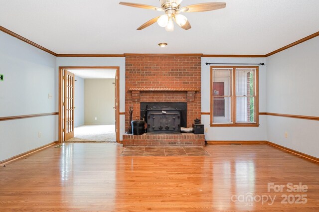unfurnished living room featuring a ceiling fan, baseboards, ornamental molding, and wood finished floors