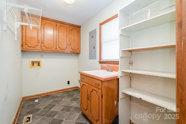 clothes washing area featuring visible vents, hookup for a washing machine, electric panel, a sink, and cabinet space