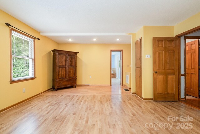 empty room with light wood-style floors, baseboards, recessed lighting, and visible vents