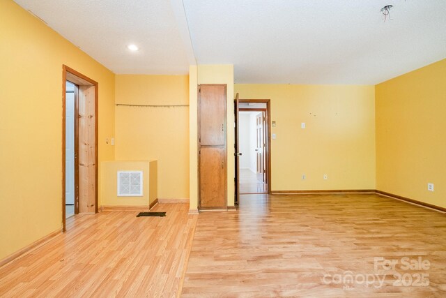 spare room featuring recessed lighting, baseboards, visible vents, and light wood-style floors