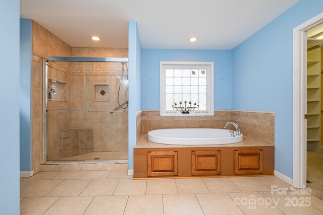 bathroom featuring recessed lighting, tile patterned floors, a bath, a spacious closet, and a shower stall