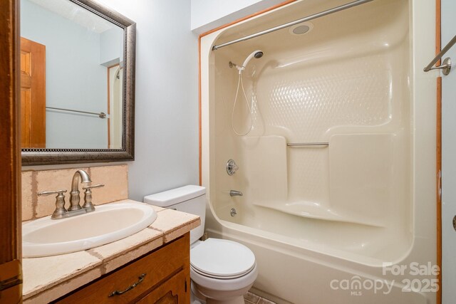 bathroom featuring vanity, shower / bathtub combination, toilet, and tasteful backsplash