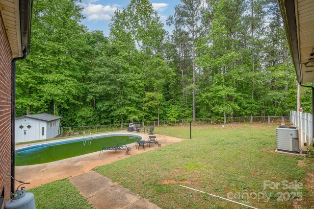view of yard with central AC, a fenced in pool, a fenced backyard, and a patio area