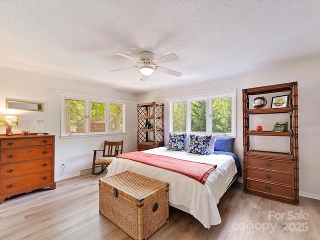 1278 Island Creek Dr, Troy, NC 27371 - bedroom featuring light wood finished floors, a textured ceiling, and multiple windows