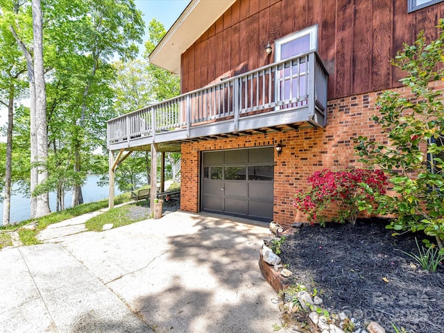 1278 Island Creek Dr, Troy, NC 27371 - view of side of home featuring a water view, concrete driveway, a garage, brick siding, and a balcony